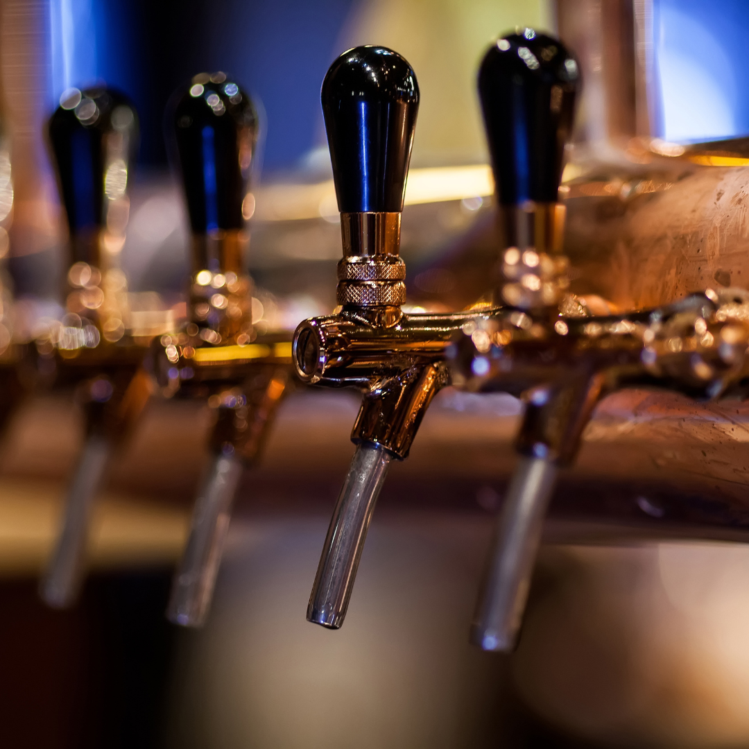 brass and black beer taps at a craft brewery